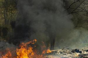 feu dans la rue. fumée et feu. la décharge brûle. dangers environnementaux. photo