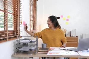 tableau de calendrier de rappel de papier collant. un comptable ou une entreprise utilise des post-it pour partager une idée sur une note autocollante. notion de comptabilité photo