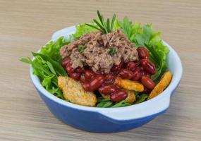 Salade de thon dans un bol sur fond de bois photo