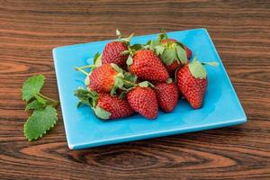 fraise fraîche sur la plaque et le fond en bois photo