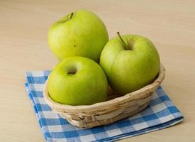 Pomme verte dans un panier sur fond de bois photo