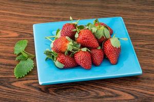 fraise fraîche sur la plaque et le fond en bois photo