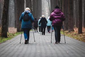 pole walking pour les personnes âgées, groupe de femmes marchant pour une bonne santé dans le parc photo