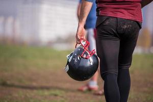 joueur de football américain tenant un casque photo