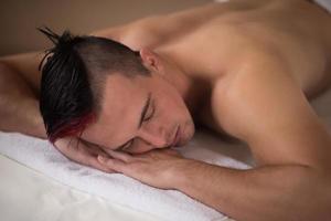 bel homme se reposant dans un centre de massage spa photo