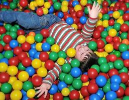 enfant heureux en boules colorées photo
