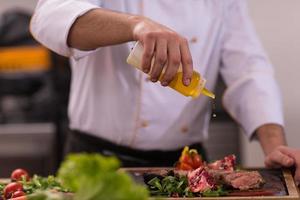 chef finissant une assiette de viande de steak photo