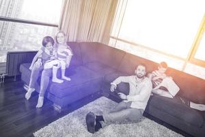 jeune famille heureuse jouant ensemble sur un canapé photo
