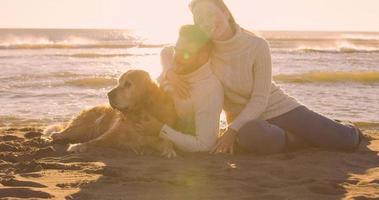 couple avec chien profitant du temps sur la plage photo