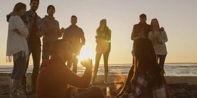 amis s'amusant à la plage le jour de l'automne photo