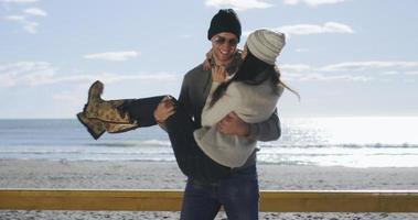 couple s'amusant lors d'une belle journée d'automne à la plage photo