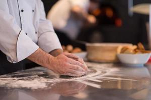 mains de chef préparant la pâte pour la pizza photo