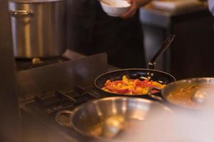 chef retournant les légumes au wok photo