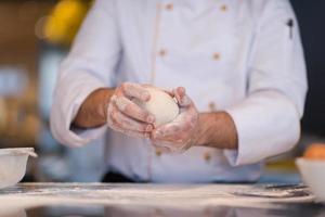 mains de chef préparant la pâte pour la pizza photo