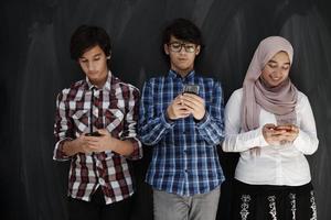 groupe d'adolescents arabes utilisant des téléphones intelligents pour les réseaux sociaux photo