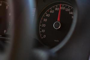 haute vitesse sur le compteur de vitesse dans l'automobile sur fond sombre photo