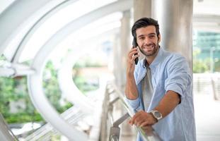 l'homme d'affaires parle avec un téléphone intelligent sur son chemin. se sentir heureux et relaxant, jeune homme d'affaires décontracté portant une veste de costume. photo