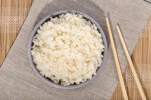 vue de dessus du riz dans un bol avec des baguettes