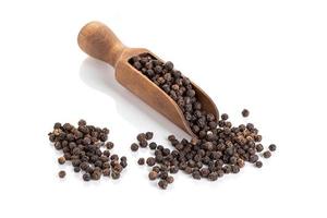 grains de poivre noir dans une cuillère en bois photo