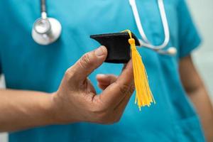 étude de médecin asiatique apprendre avec un chapeau d'écart de graduation dans la salle d'hôpital, concept de médecine d'éducation de génie brillant intelligent. photo