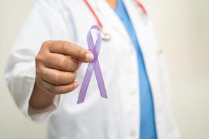 femme médecin asiatique avec ruban violet, signe de la journée de la maladie d'alzheimer, cancer du pancréas, épilepsie, lupus. photo