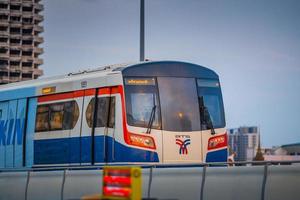 bangkok, thaïlande 29 mai bts sky train passant le pont taksin saphan taksin ou saphan sathorn dans la soirée du 29 mai 2022 à bangkok, thaïlande. photo