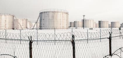 réservoirs de stockage de gaz en hiver, réservoir derrière une clôture surmontée de barbelés photo