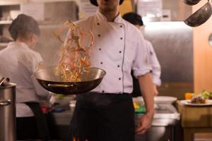 chef retournant les légumes au wok photo