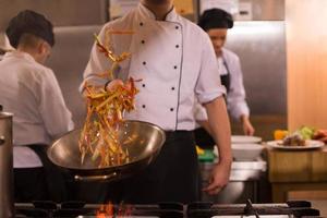 chef retournant les légumes au wok photo