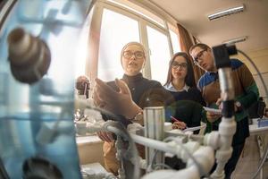 jeunes étudiants faisant la pratique dans la salle de classe électronique photo