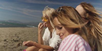 groupe de copines s'amusant sur la plage pendant la journée d'automne photo