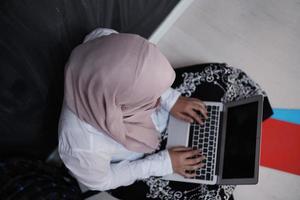 Étudiante arabe travaillant sur ordinateur portable à la maison photo