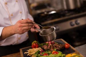 chef finissant une assiette de viande de steak photo