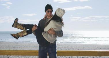 couple s'amusant lors d'une belle journée d'automne à la plage photo