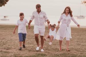 couple de personnes âgées en vêtements décontractés avec leurs enfants, garçon et fille profitent de la plage pour passer des vacances ensemble. du temps en famille . mise au point sélective photo