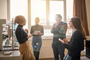 jeunes étudiants faisant la pratique dans la salle de classe électronique photo