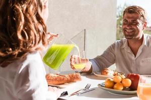 couple de personnes âgées mangeant un petit déjeuner sain ensemble tôt le matin dans une maison de luxe. mise au point sélective photo