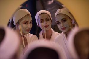 femmes mettant des masques faciaux dans la salle de bain photo