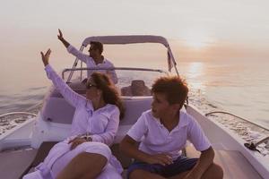 un couple de personnes âgées en tenue décontractée avec leur fils profite d'un bateau en mer au coucher du soleil. le concept d'une famille heureuse. mise au point sélective photo