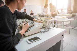 étudiants faisant la pratique dans la salle de classe électronique photo