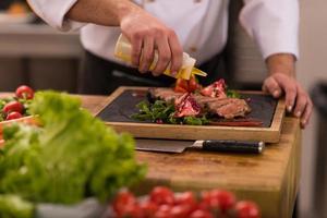 chef finissant une assiette de viande de steak photo