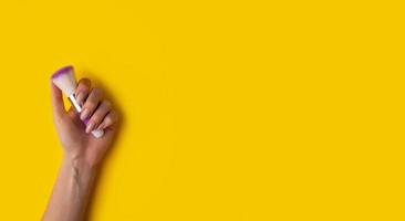 mains féminines avec une belle manucure sur fond jaune, vue de dessus photo