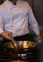 chef préparant la nourriture, faisant frire dans la casserole de wok photo