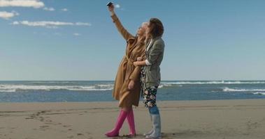 filles ayant du temps et prenant un selfie sur une plage photo