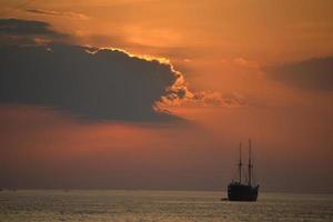 silhouette d'un bateau au coucher du soleil photo