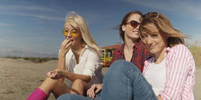 groupe de copines s'amusant sur la plage pendant la journée d'automne photo