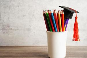 chapeau de graduation avec des crayons colorés sur un livre avec espace de copie, apprentissage du concept d'éducation universitaire. photo