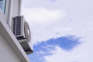 Compresseur de l'unité extérieure de climatisation installé à l'extérieur de la maison avec un ciel bleu photo