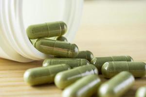 Capsules de phytothérapie avec bouteille sur table en bois photo