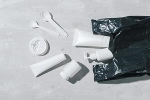 pas de concept de recyclage du plastique Plats en plastique blanc assiettes tasses cuillère sur fond de pierre. espace de copie. vue de dessus photo